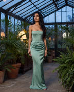 Valentina gown in sage green worn in a glass conservatory at dusk – Belle Marisol